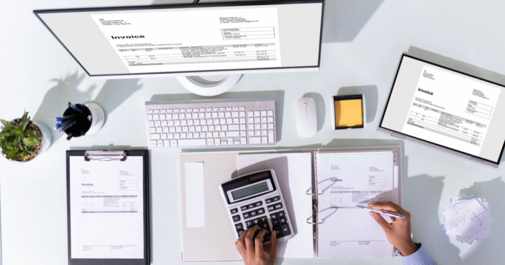 Making Tax Digital - an image of someone doing their tax calculations over invoices on a computer