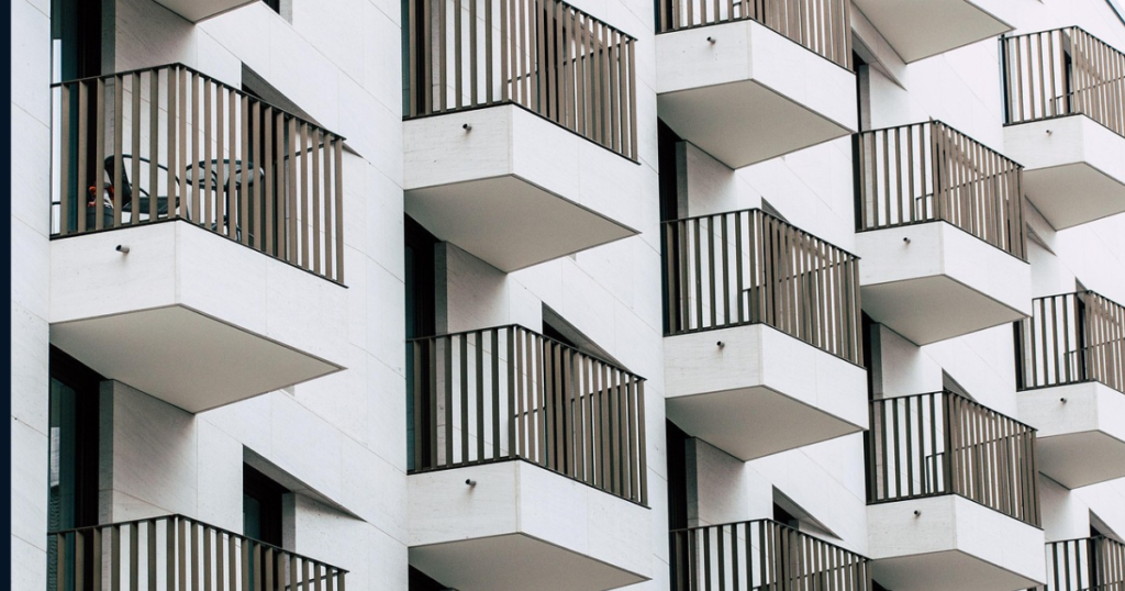 Neighbour's property from outdoors, white building and black balconies with modern design.